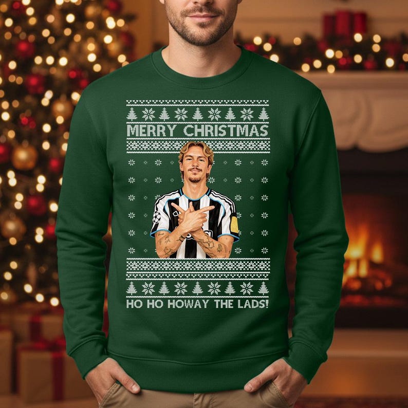 Puede incluir: Jersey navide&ntilde;o verde oscuro con un dise&ntilde;o festivo. El jersey presenta el texto "MERRY CHRISTMAS" y "HO HO HOWAY THE LADS!". Tambi&eacute;n incluye un gr&aacute;fico de una persona con una camiseta a rayas blancas y negras. El jersey es de cuello redondo.