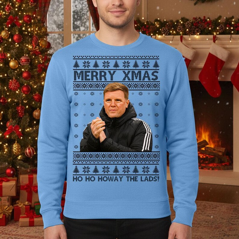 May include: Light blue Christmas sweater with the text "MERRY XMAS" and "HO HO HOWAY THE LADS!". The sweater features a portrait of a man in a black jacket. The design includes snowflakes and Christmas trees.