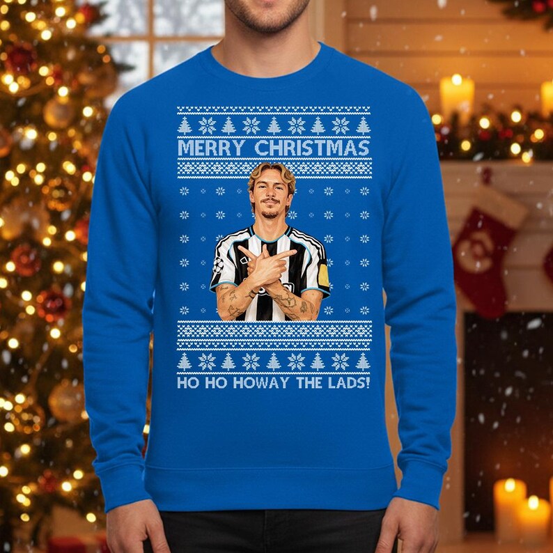 Puede incluir: Un jersey navide&ntilde;o azul real con un retrato de un hombre con los brazos cruzados. El jersey tiene patrones de copos de nieve y &aacute;rboles de Navidad blancos, con el texto "MERRY CHRISTMAS" y "HO HO HOWAY THE LADS!"