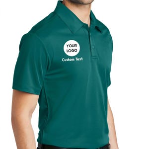 a man wearing a green polo shirt and black pants