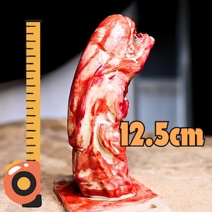 May include: A red and white alien creature figurine, standing 12.5 inches tall, next to a measuring tape.