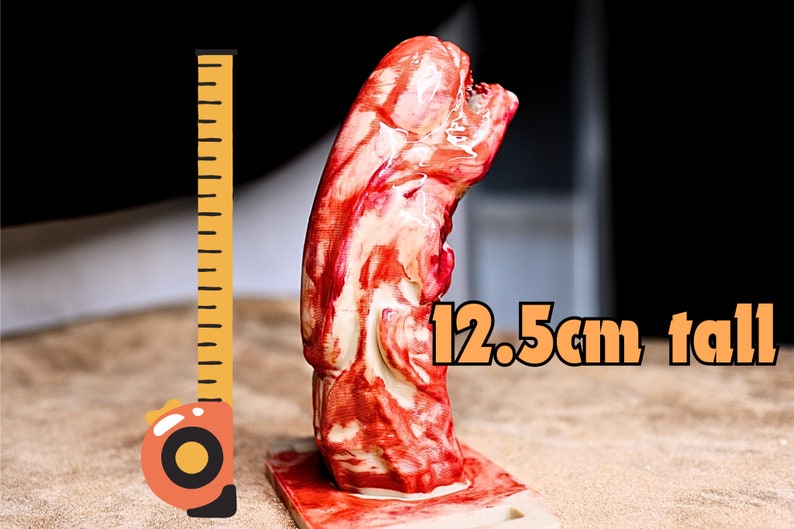 May include: A red and white alien creature figurine, standing 12.5 inches tall, next to a measuring tape.