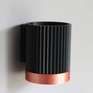 May include: A black and copper wall-mounted cup holder with a ribbed design.