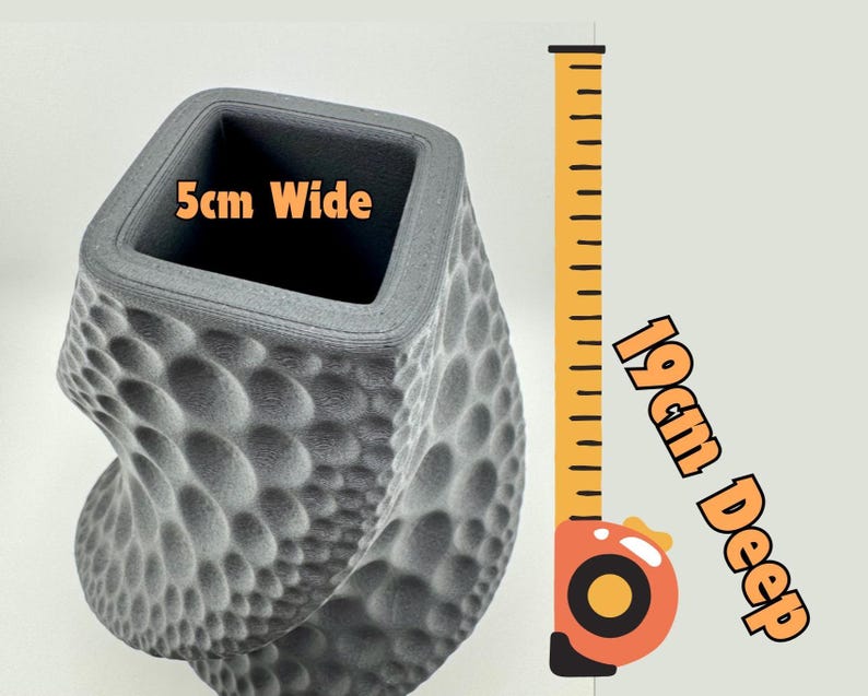 May include: A gray, textured vase with a unique, bubble-like pattern. The square opening is 2 inches wide, and the vase is 7.5 inches deep. The design is a modern, artistic take on a decorative container.