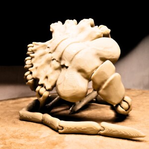 May include: A 3D printed model of a skull with a detailed bone structure. The skull is beige and has a textured surface. The skull is sitting on a brown surface.