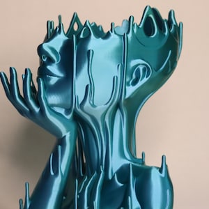 May include: A teal blue abstract sculpture of a person with their head tilted back and hands raised to their face. The sculpture is made of a smooth, flowing material that resembles liquid.