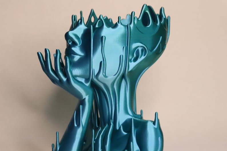 May include: A teal blue abstract sculpture of a person with their head tilted back and hands raised to their face. The sculpture is made of a smooth, flowing material that resembles liquid.