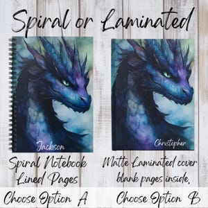 May include: Two notebook cover options featuring a watercolor illustration of a blue dragon with green eyes. The left option is a spiral notebook with lined pages and the text "Jackson" printed on the cover. The right option is a matte laminated cover with blank pages and the text "Christopher" printed on the cover.