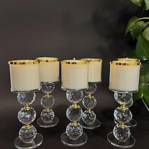 Puede incluir: Juego de seis candelabros de cristal transparente con detalles dorados. Cada candelabro tiene una base redonda y tres niveles de bolas de cristal facetadas. Los candelabros son perfectos para añadir un toque de elegancia a cualquier decoración del hogar.