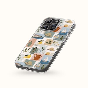 May include: A clear phone case with a colorful, patterned design. The pattern features squares with illustrations of hats, lemons, sailboats, and teapots in shades of blue, beige, and brown. The case has a black border and covers the phone's camera.