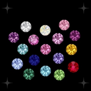 May include: Assortment of colourful rhinestones in various shades of blue, green, red, pink, purple, and yellow. The rhinestones are arranged in a semi-circle pattern on a black background.