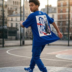 May include: A person wearing a blue t-shirt and matching pants. The t-shirt features a graphic with the word "FRANCE" and an image. The person is also wearing blue sneakers with white accents.