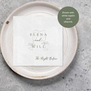 Personalized rehearsal dinner napkin in olive green ink, champagne flutes with bow accent, white napkin