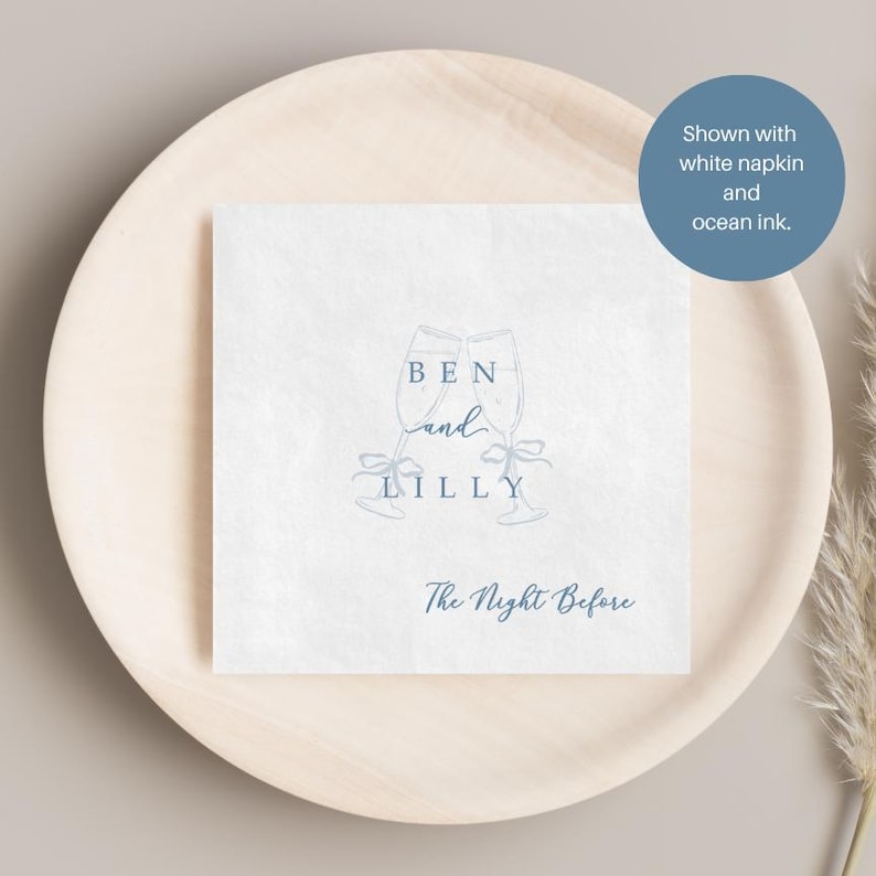 Personalized rehearsal dinner napkin in dusty blue ink, champagne flutes with bow accent, white napkin