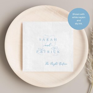 Personalized rehearsal dinner napkin in sky ink, champagne flutes with bow accent, white napkin