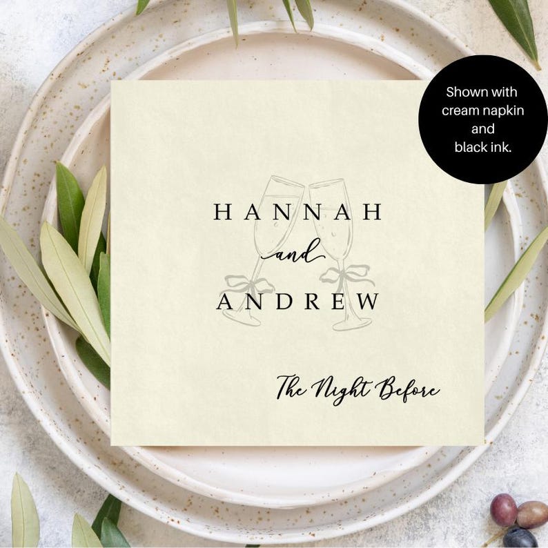 Personalized rehearsal dinner napkin in black ink, champagne flutes with bow accent, cream napkin