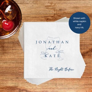 Personalized bar napkin in navy ink, champagne flutes with bow accent, white napkin at cocktail bar
