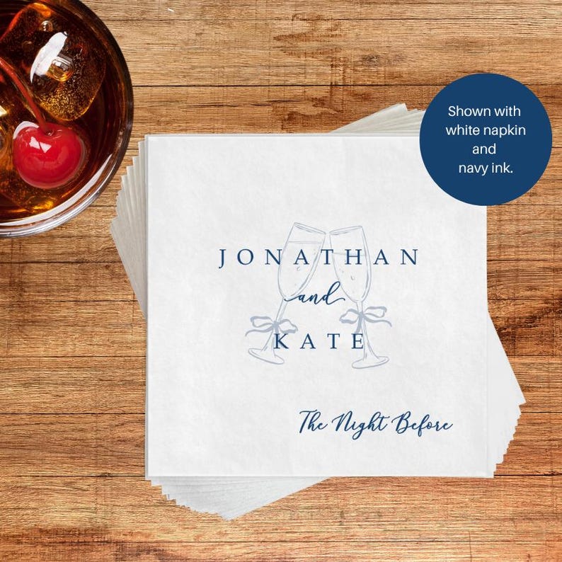 Personalized bar napkin in navy ink, champagne flutes with bow accent, white napkin at cocktail bar