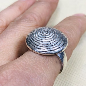 Könnte beinhalten: Set aus drei Keramikbechern mit gesprenkelter, matter Oberfläche. Die Becher sind in Creme-, Hellgrau- und Dunkelgrautönen gehalten. Jeder Becher hat ein schlichtes, minimalistisches Design.