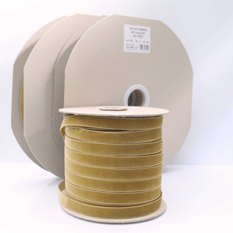 May include: A spool of gold velvet ribbon. The ribbon is wound around a cardboard spool with a label that reads "Velvet Ribbon,  Velour, Art. 0322".