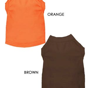 May include: Two dog shirts, one orange and one brown. The shirts are plain and have a crew neck.