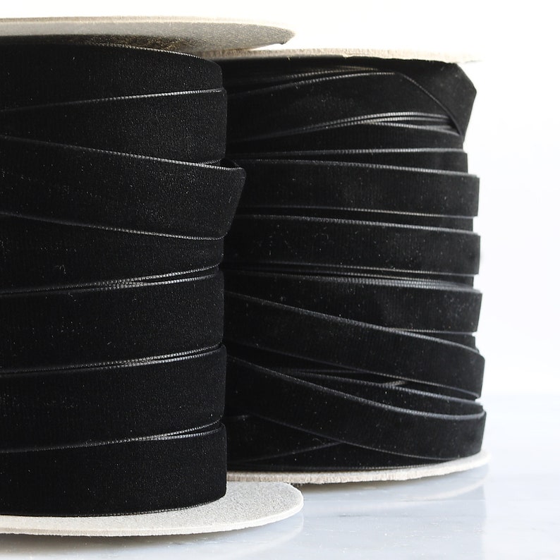 May include: Two spools of black velvet ribbon, wound tightly on cardboard spools.