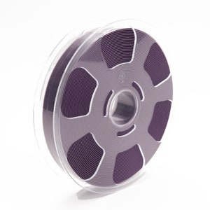 Peut inclure: Une bobine de filament violet pour l'impression 3D dans un r&eacute;cipient en plastique transparent.