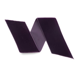 Peut inclure: Un ruban de velours violet, pli&eacute; en forme de vague, isol&eacute; sur un fond blanc.