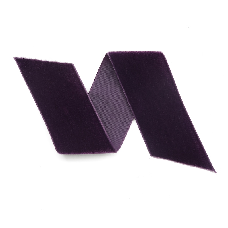 Peut inclure: Un ruban de velours violet, pli&eacute; en forme de vague, isol&eacute; sur un fond blanc.