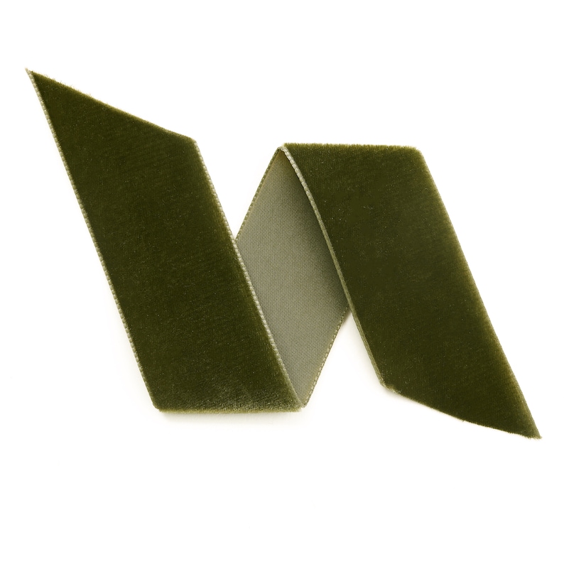 May include: A green velvet ribbon folded into a zig-zag shape. The ribbon is soft and has a subtle sheen.