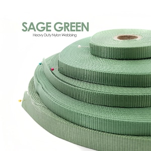 May include: Sage green heavy duty nylon webbing rolls stacked on top of each other. The webbing is a light green colour.