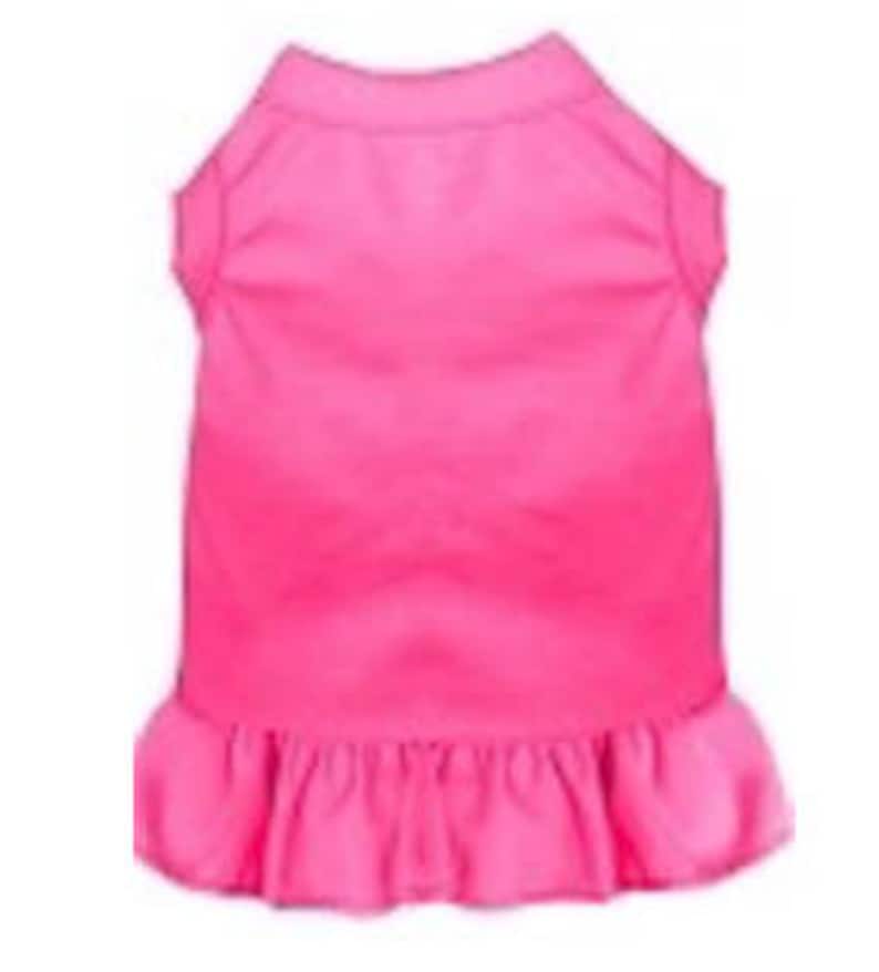May include: A bright pink sleeveless dog dress with a ruffled hem.