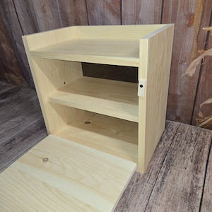 May include: A light wood shoe rack with a hinged door and two shelves. The door is open and the shelves are empty.