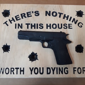 There's Nothing In This House Worth You Dying For Wood Sign. 9" x 11" x 1" wooden 3d Semi Automatic pistol With Simulated Bullet Holes