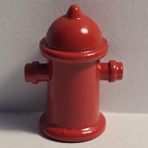 May include: A red fire hydrant toy with a rounded top and two side handles.