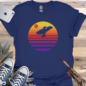 May include: A navy blue t-shirt with a retro sunset graphic featuring a spaceship silhouette. The sunset is in shades of orange, yellow, red, and purple.