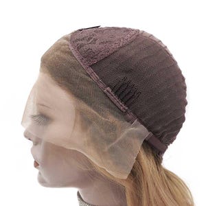 May include: A brown lace front wig cap with a mesh base. The cap features a lace front that extends across the forehead and a brown mesh back. The wig cap is designed to be worn under a wig to protect the natural hair.