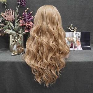 May include: A long, wavy blonde wig with a natural-looking hairline. The wig features voluminous curls and a light golden color, perfect for cosplay or everyday wear. The wig is styled to fall down the back.