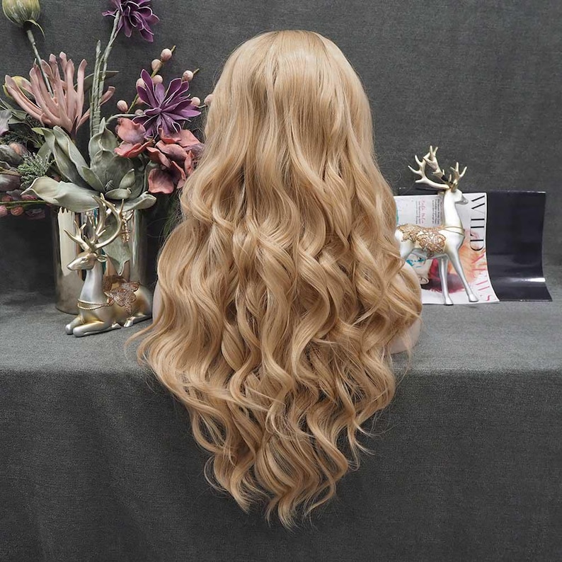 May include: A long, wavy blonde wig with a natural-looking hairline. The wig features voluminous curls and a light golden color, perfect for cosplay or everyday wear. The wig is styled to fall down the back.
