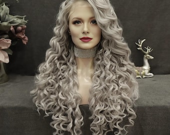 May include: A long, wavy, silver-grey wig with a lace front. The wig features voluminous, tightly curled locks. The mannequin head is adorned with a sparkling choker. The background is a muted grey.