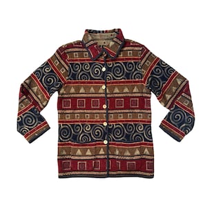 May include: A patterned button-down jacket in brown, red, and navy blue. The jacket has a collar and long sleeves. The design incorporates swirls, squares, and triangles. The jacket is fastened with buttons.