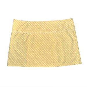 May include: A yellow and white gingham pattern skirt. The skirt has a straight cut and a white trim along the top edge. The fabric is a light, summery material.