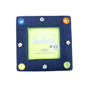 May include: Square denim photo frame with a green interior and the text "ANY GENERATION". The frame is decorated with small white flower accents and colorful circular accents. The frame is designed for a 4" x 4" photograph.