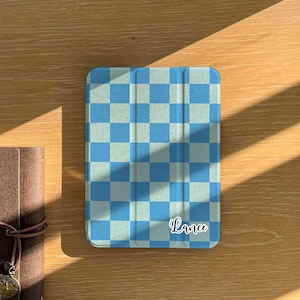 May include: A blue and white chequered iPad case with the name "Lance" written in white on the bottom right corner.