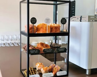 Vitrine de comptoir à plusieurs niveaux en acrylique pour boulangerie, avec cadre en métal, idéale pour présenter pâtisseries, pains et desserts en magasin.