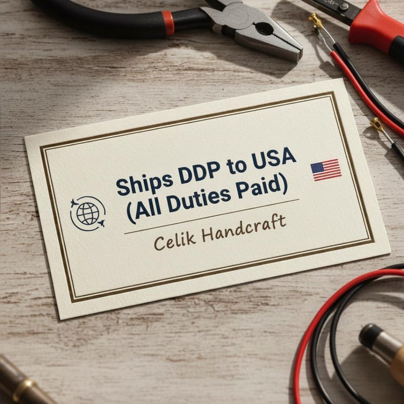 May include: A cream-colored business card with a dark brown border displays the text "Ships DDP to USA (All Duties Paid)" and a small American flag. The card also includes the text "Celik Handcraft" and a globe icon.