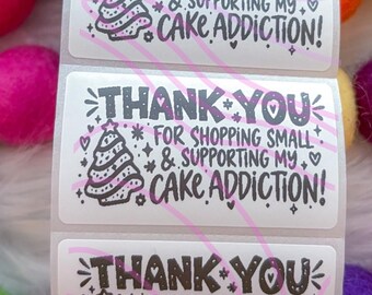 May include: Three rectangular white stickers featuring black text that reads THANK YOU FOR SHOPPING SMALL & SUPPORTING MY CAKE ADDICTION! Each sticker includes a graphic of a decorated Christmas tree, hearts, and stars with pink diagonal lines.