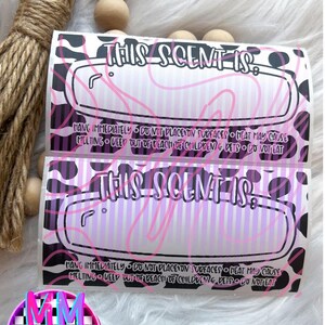 May include: Two rectangular labels with the text "THIS SCENT IS:" in a pink, purple, and black design. The labels have a striped background and a cow print border. The text "HANG IMMEDIATELY" is also visible.