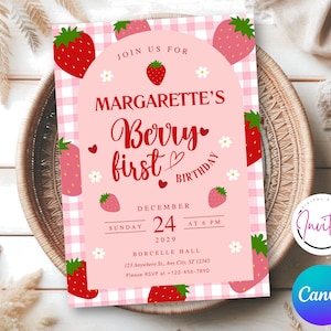 May include: A pink and white gingham-patterned invitation with strawberry illustrations. The text reads "Margarette's Berry First Birthday" with the date December 24, 2029. The invitation is set on a woven tray.