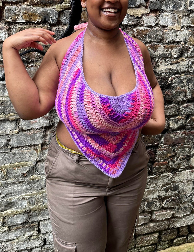 A vibrant, crochet bandana top in bright shades of pinks and purples displayed on a size extra-large model. The top features a simple yet stylish design, perfect for beginners. Created using Linda Made This beginner-friendly crochet pattern.